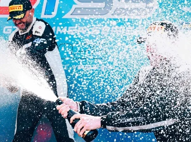 Fahrer spritzen mit Champagner auf dem Podium der GT Summer Series