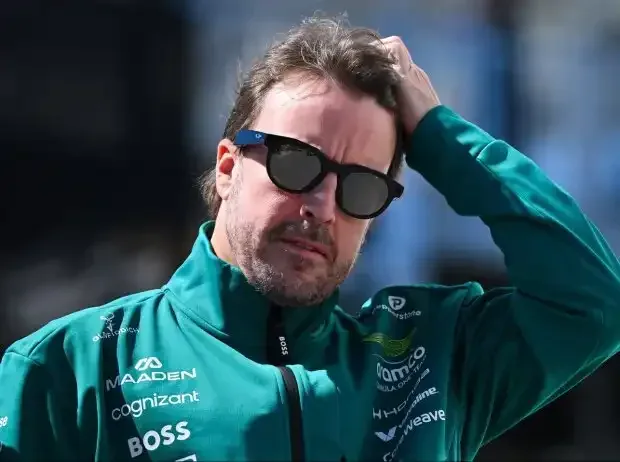 Title image for the news: Fernando Alonso in a half-portrait with sunglasses, running a hand through his hair