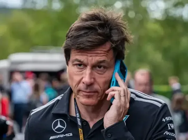 Title image for the news: Mercedes team principal Toto Wolff on the phone in the Formula 1 paddock
